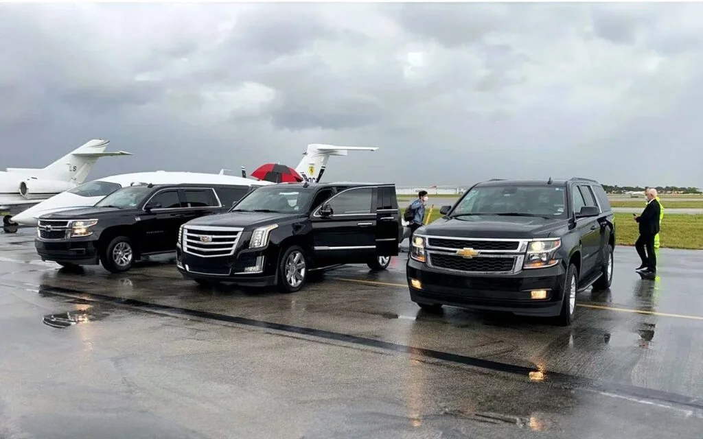 three limos are parked with the chauffeurs for delivering the oakville airport limo service
