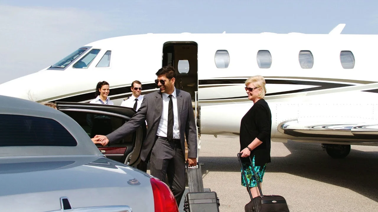 kitchener airport limo services-A woman smiles while pulling a suitcase toward a private jet. Two pilots stand by, and a man in a suit opens a car door, conveying luxury and travel.
