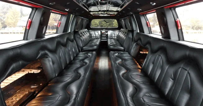 inside the luxury airport limo-Luxurious stretch limo interior with sleek black leather seating lining both sides. Soft lighting under seats and large windows create an elegant, spacious feel.