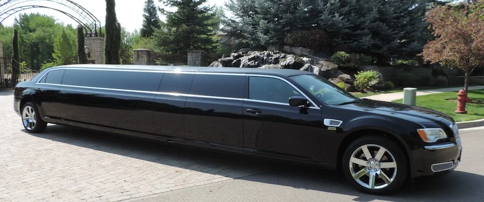 advance limo booking Toronto- A sleek black limousine is stationed on a driveway, showcasing its polished exterior.