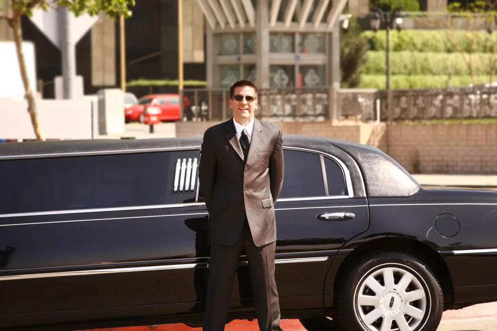 buffalo airport limo service-A suited individual stands confidently next to a sleek black limousine in a modern urban setting.