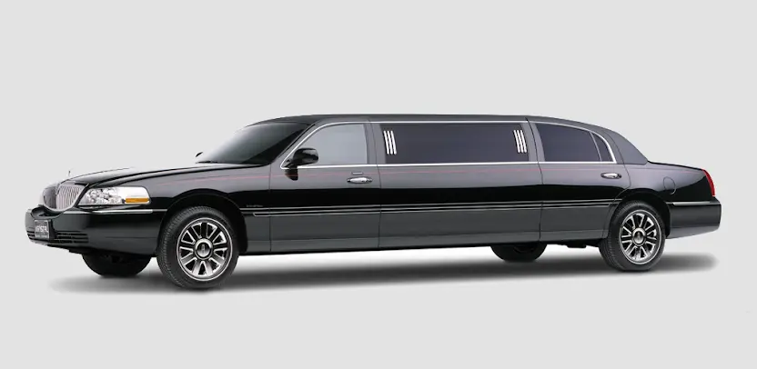 10 perks of choosing Toronto airport limo for business-A sleek white limousine SUV is parked on a cobblestone driveway. Tall palm trees and a luxurious hotel are in the background, conveying elegance and opulence.