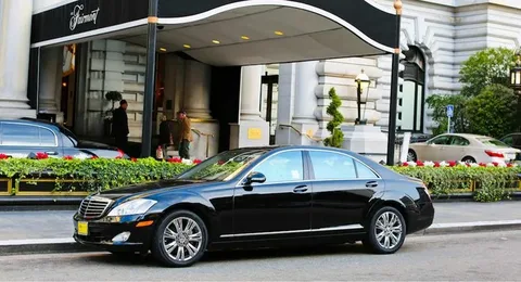 hamilton limo service- A black sleeked limo sedan with silver rims parked infront of a beautiful house
