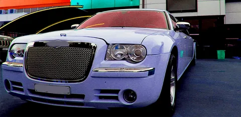 markham limo service-A sleek, light blue luxury car with a chrome grille and bold headlights is parked outdoors. The background is vibrant, featuring modern architecture.