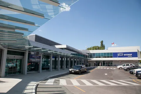 billy bishop aitport li,mo-Modern airport exterior with glass canopy, blue sky, and asphalt driveway. Several cars parked in front. Sign reads "Billy Bishop Airport."